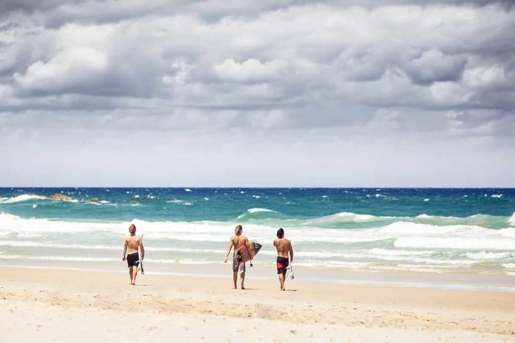Surfeurs sur la plage de Byron Bay